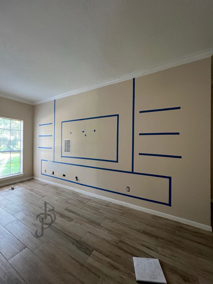 The same living room wall marked out with painter's tape before the media wall build