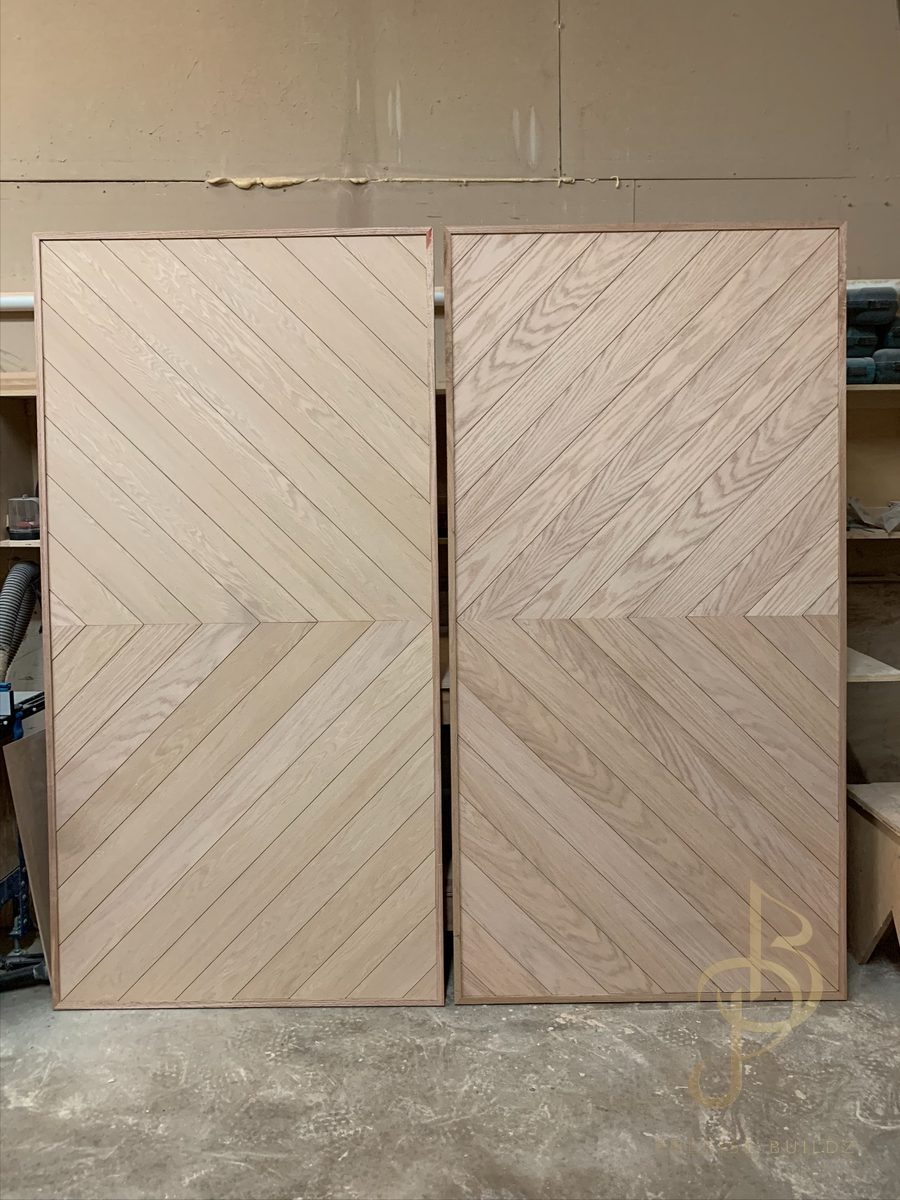 Pair of custom chevron-pattern white oak sliding barn doors in the shop