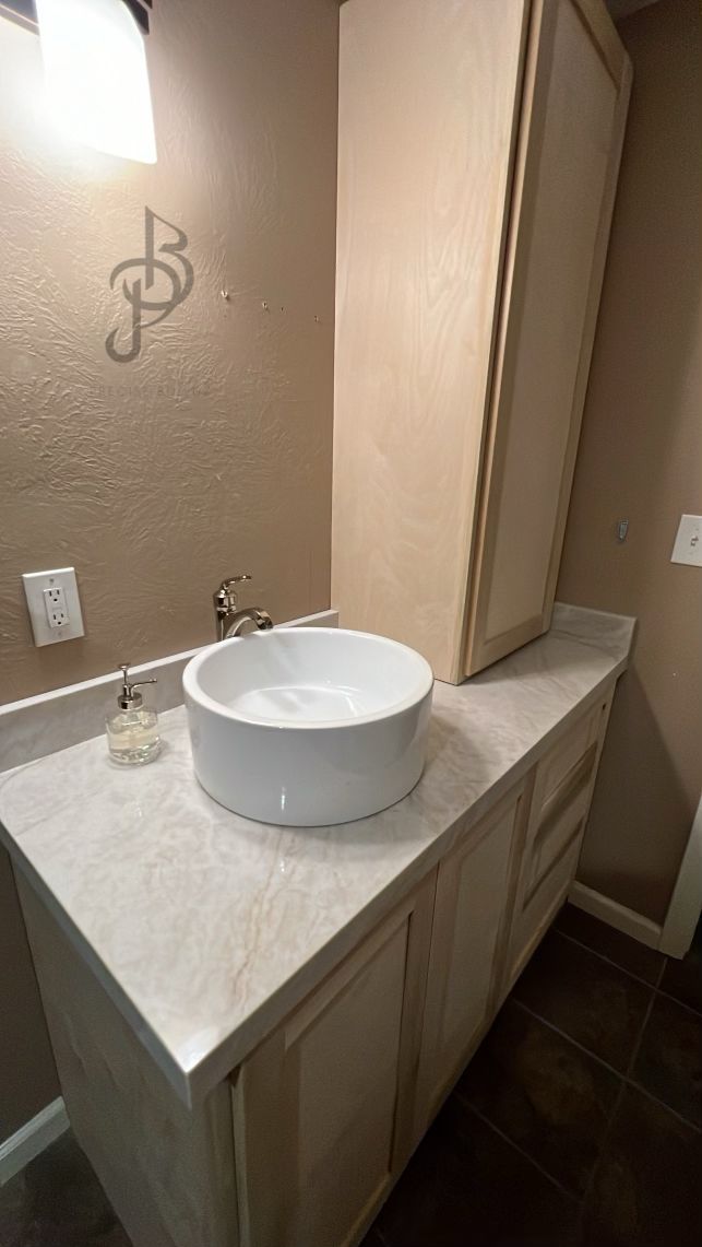 Custom shaker bathroom vanity with a round white vessel sink and marble-look countertop