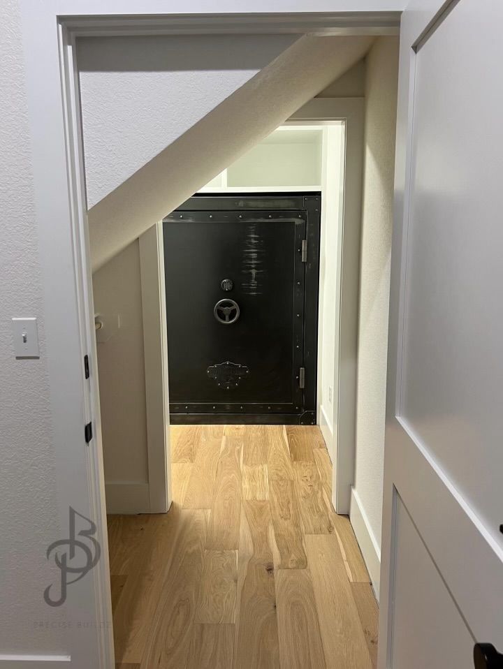 Security vault door integrated seamlessly under main staircase