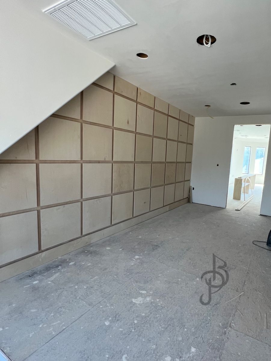 Close-up detail of geometric wood accent wall joints under construction