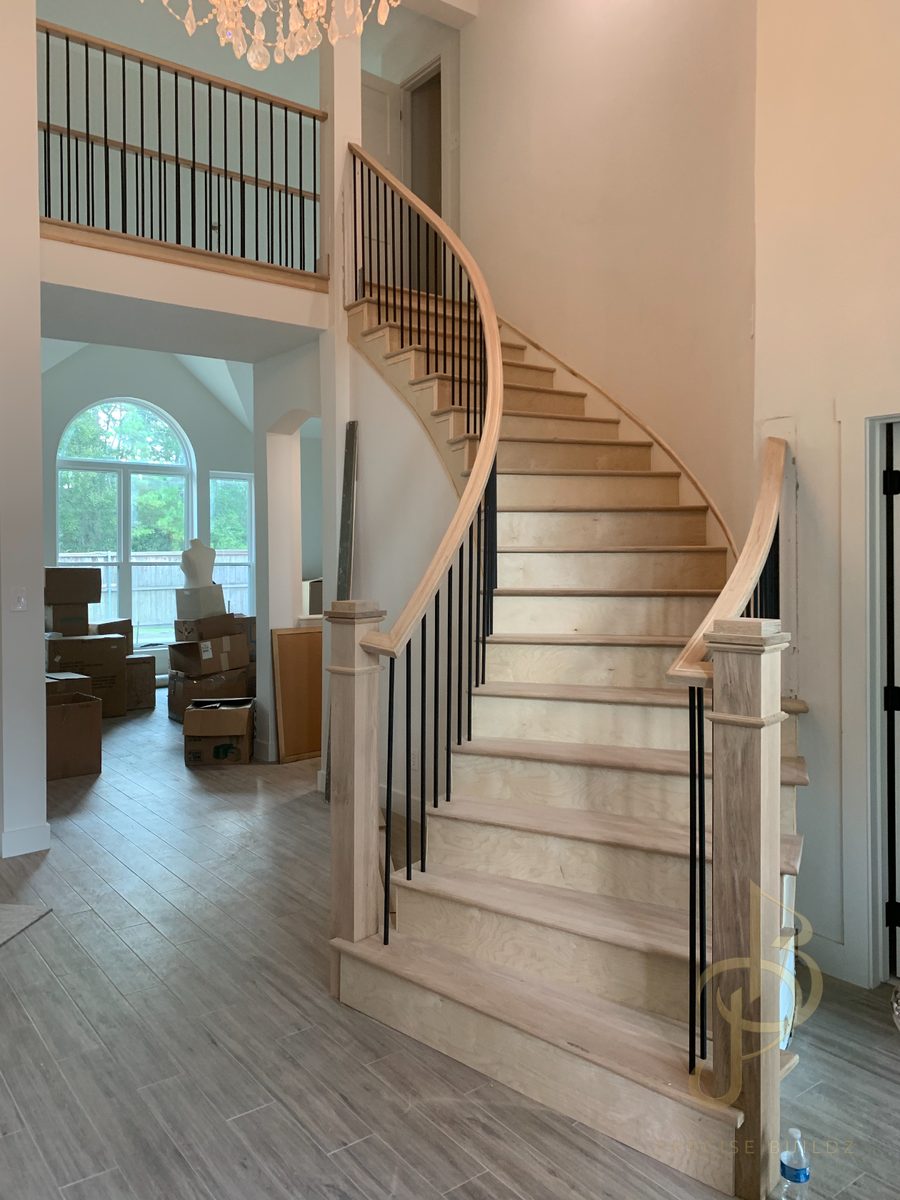 Finished curved staircase with solid oak treads, curved handrail, and iron balusters