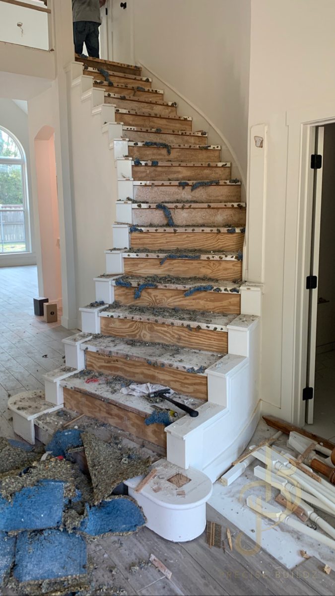 Curved staircase stripped to plywood during demolition, before new oak treads